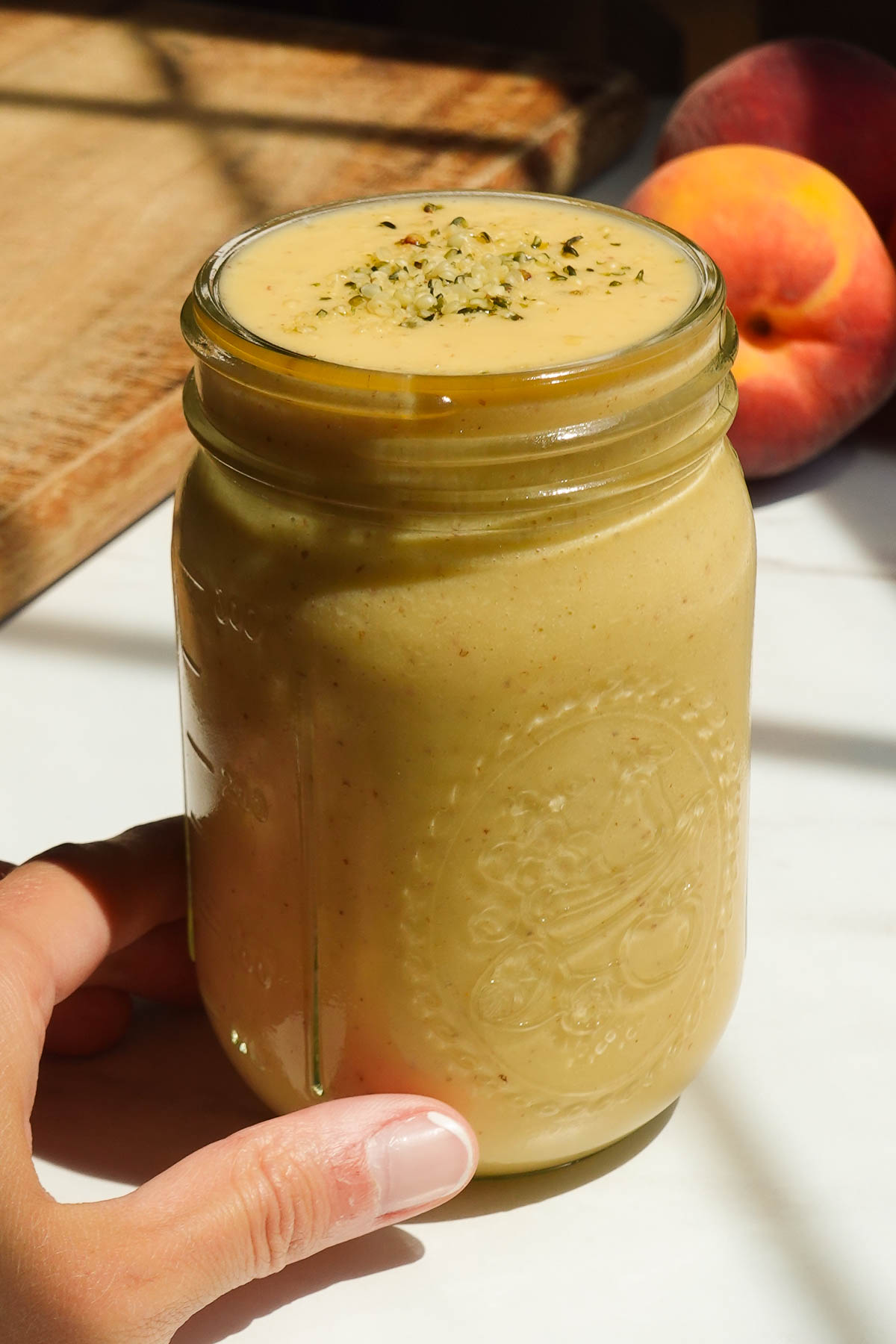 Thick and creamy peach mango smoothie in a glass.