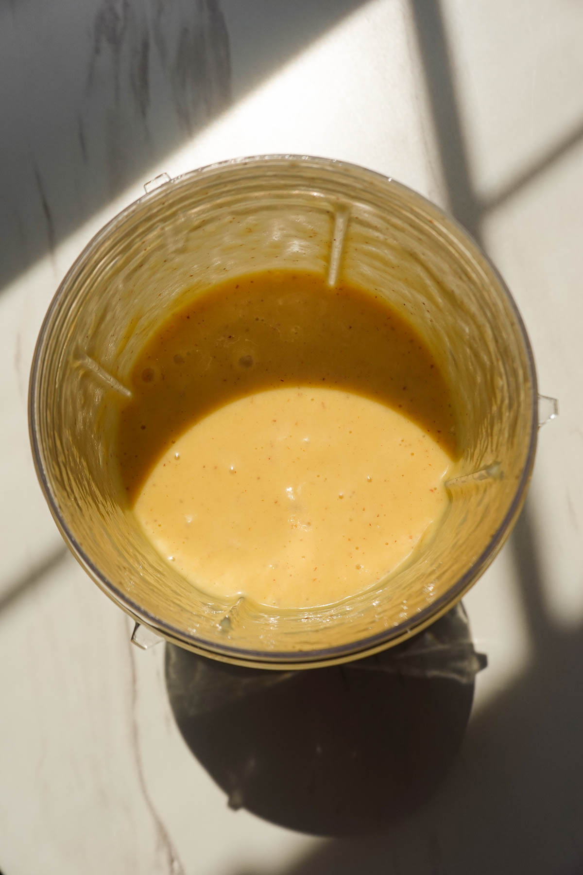Frozen peaches and mango blended with milk and orange juice for a peach mango smoothie.