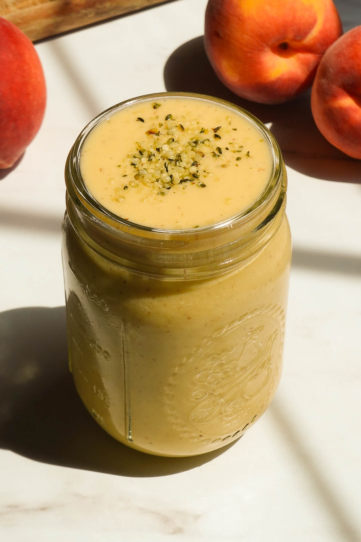 Creamy peach mango smoothie served in a glass.