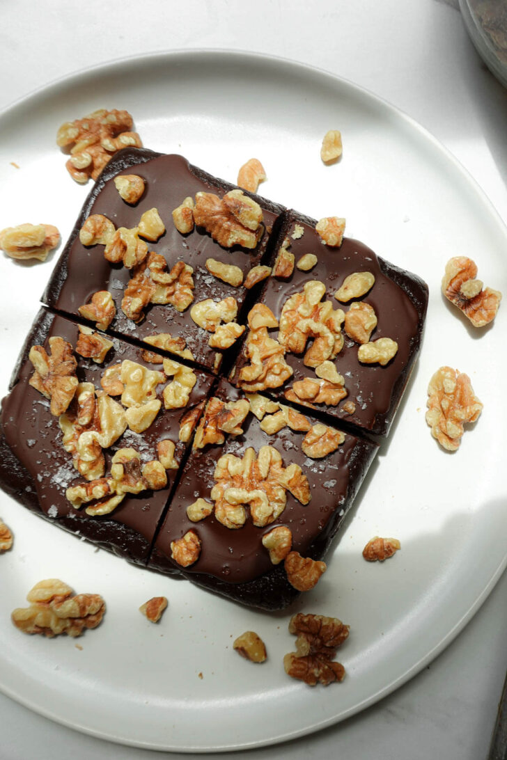 No bake walnut date brownies topped with vegan chocolate and walnuts.