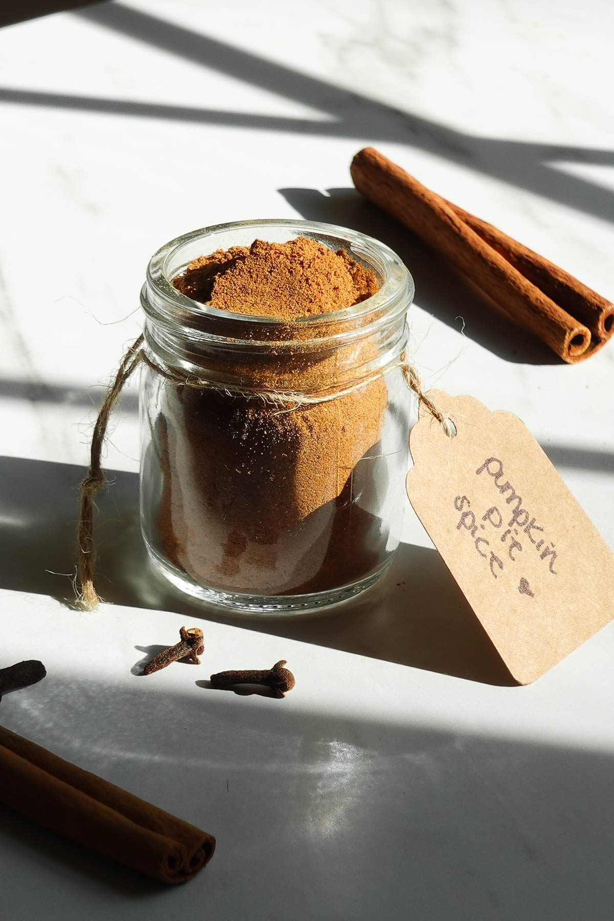 Homemade pumpkin pie spice in a small glass jar.