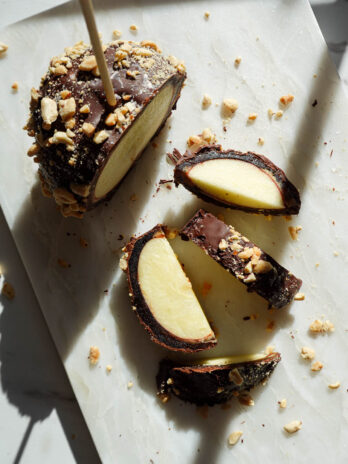 Date caramel apple slices showing crisp apple, a medjool date layer, and a chocolate shell.