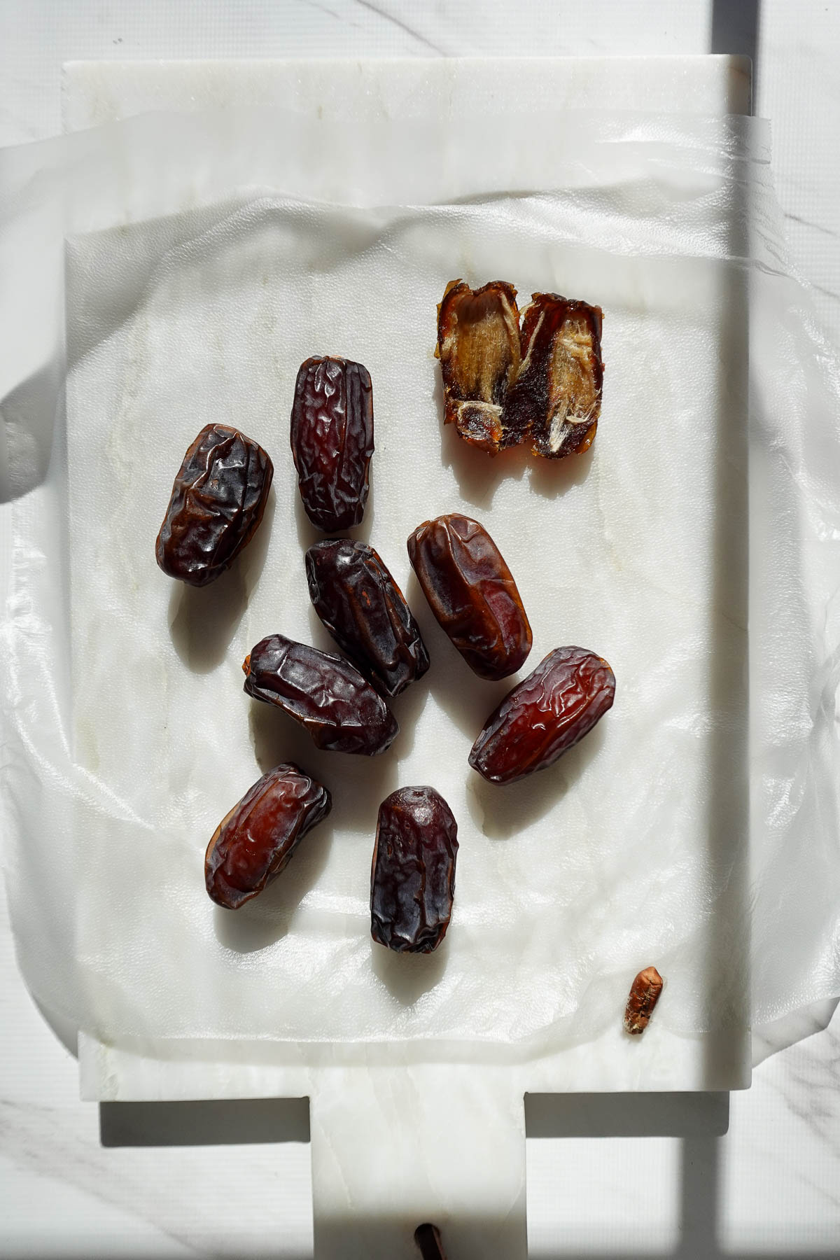 Arranging whole medjool dates on plastic wrap.