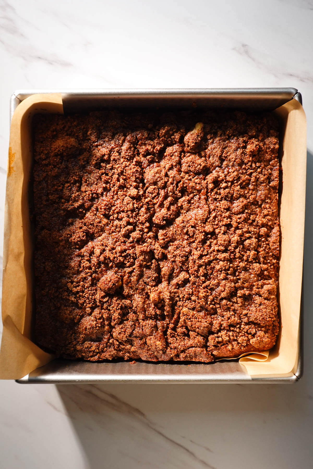 Freshly baked vegan pumpkin coffee cake with a golden cinnamon-walnut streusel topping.