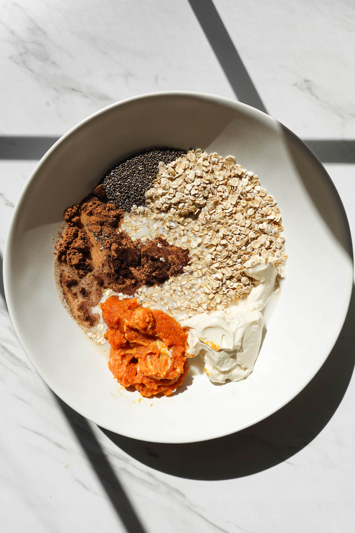Ingredients in a bowl to make pumpkin pie overnight oats.